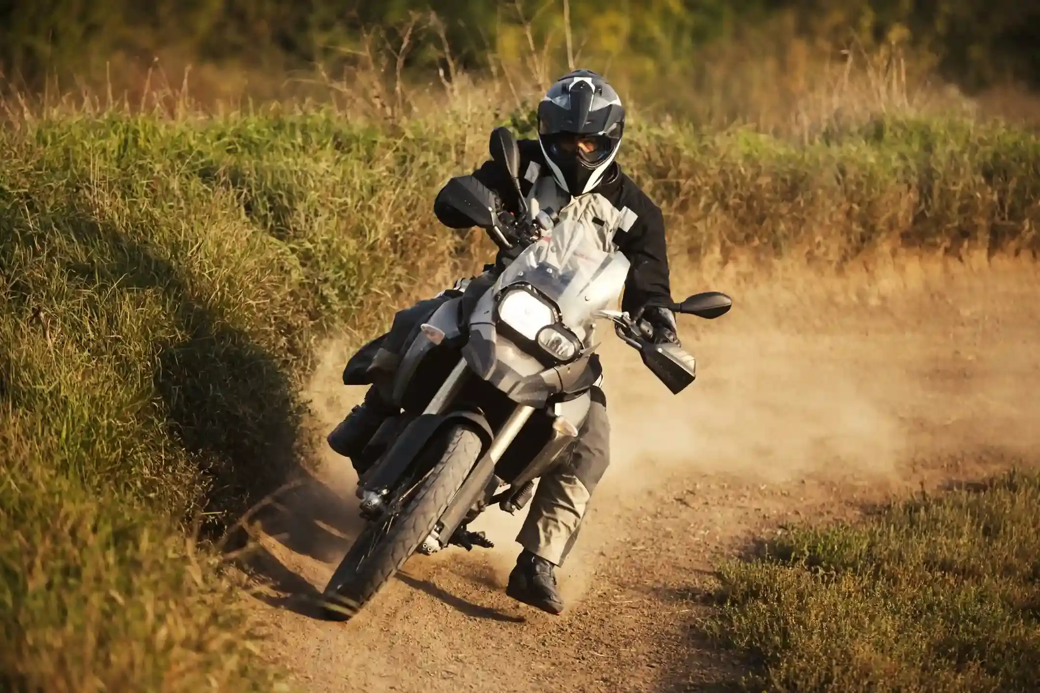 An adventure motorcycle cornering on a dusty dirt track